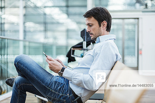 Businessman waiting in airport departure area  using digital tablet