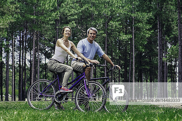 Älteres Paar mit Fahrrädern im Wald