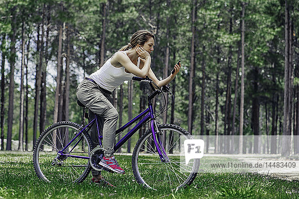 Mature woman using smart phone in forest