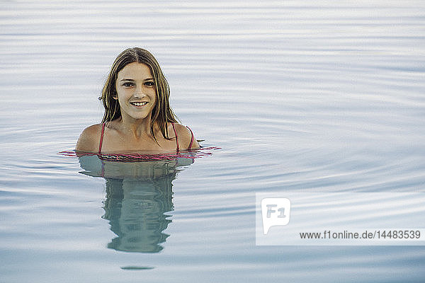 Lächelndes Mädchen schwimmt im Pool