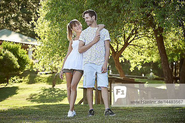 Lächelndes junges Paar im Park stehend