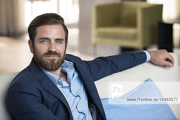 Businessman sitting on sofa in hotel lobby
