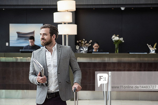Smiling businessman standing in hotel lobby