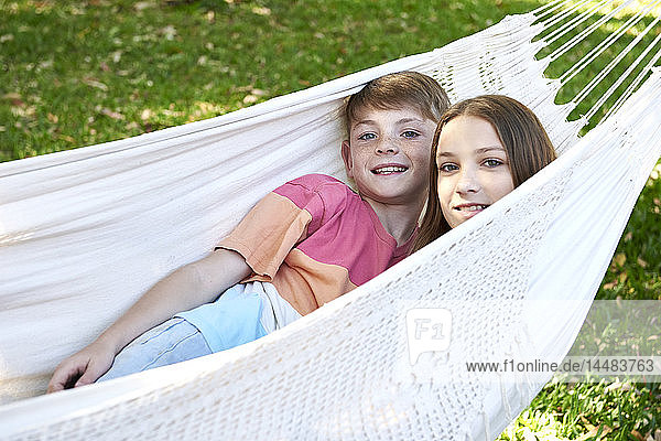 Brother and sister relaxing in a hammock