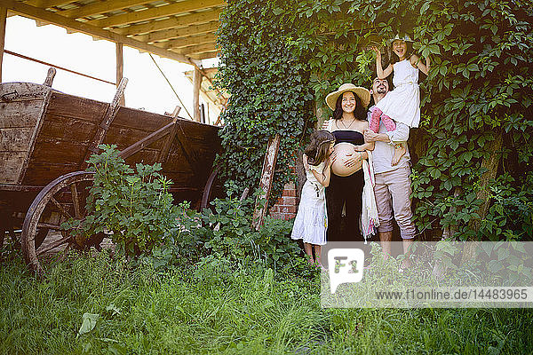 Porträt schwangere Familie im ländlichen Garten
