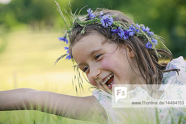 Glückliches  sorgloses Mädchen mit Blumen im Haar