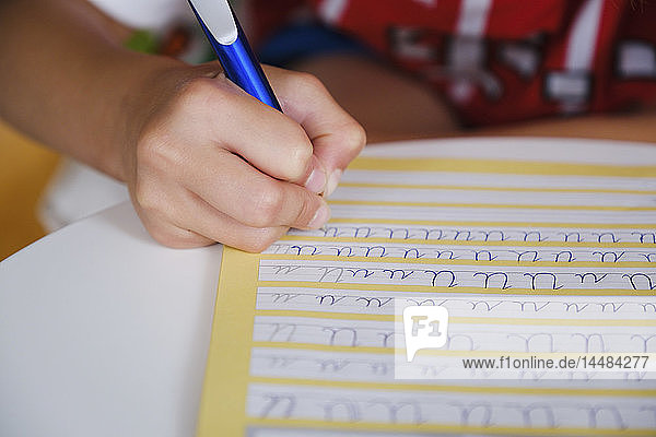 Kind übt kursive Handschrift