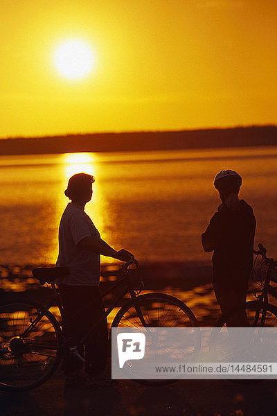Fahrradfahrer mit Blick auf Cook Inlet bei Sonnenuntergang Anchorage AK