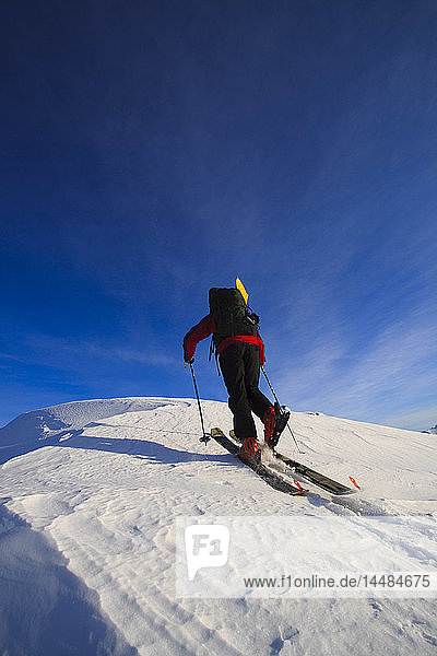 Man backcountry skiing up an icy ridge near Wrangell Peak  Tongass National Forest  Southeast Alaska  Winter