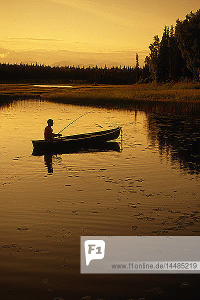 Mann fischt vom Kanu aus im See SC AK Sommer-Sonnenuntergang