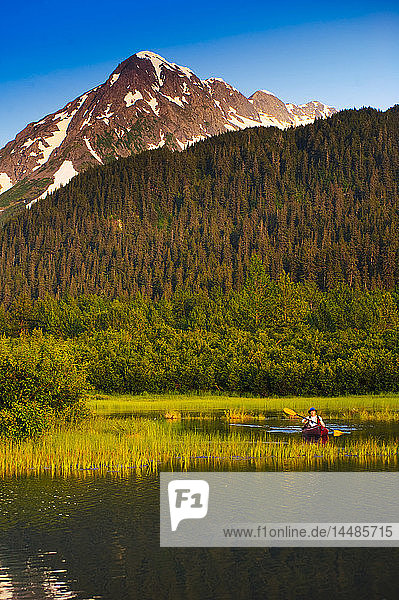 Man in a kayak paddling in a lake in Portage Valley  Southcentral  Alaska  Summer