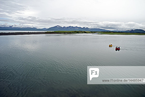 Ein Mann und eine Frau fahren mit einem Floß den Aniakchak River hinunter  der an einer Lagune an der Pazifikküste im Aniakchak National Monument and Preserve im Südwesten Alaskas endet.