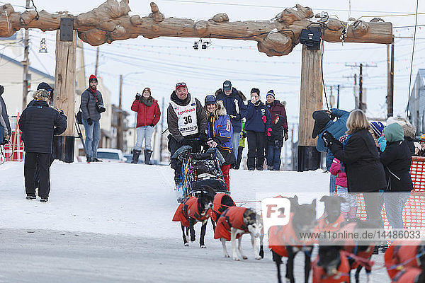 Ken Anderson and his wife leave the Nome finish chute after his arrival during Iditarod 2015
