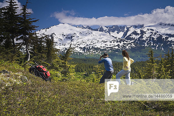 Couple hiking and viewing the Kenai Mountains from Lost Lake Trail near Seward  Alaska during Summer