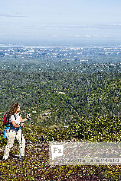 Woman hiking on McHugh Peak trail in Chugach State Park with Anchorage Alaska in background