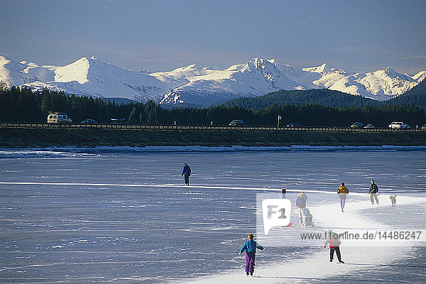 Ice skaters on Twin Lakes along Egan Expressway Juneau Alaska Southeast Winter w/Chilkat Range