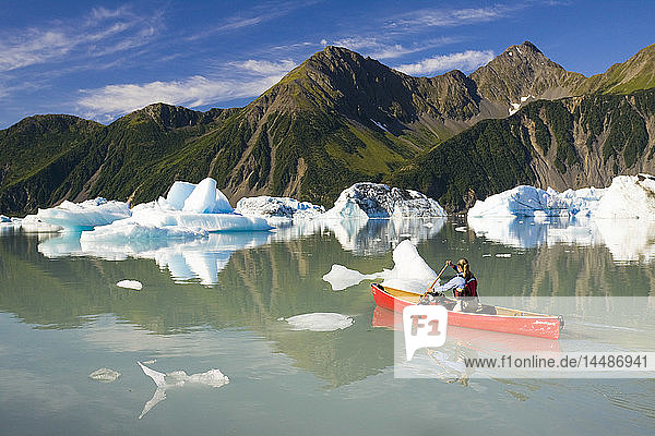 Kanufahrerin paddelt zwischen den Eisbergen im Bear Glacier Lake in der Nähe des Bear Glacier  Kenai Fjords National Park  Kenai Peninsula  Süd-Zentral-Alaska  Sommer