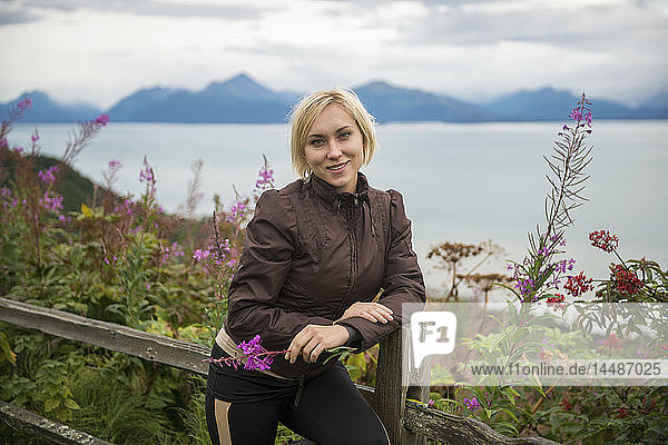 Frau steht auf einem Hügel mit Blick auf das Cook Inlet in der Nähe von Homer  Kenai-Halbinsel  Southcentral Alaska
