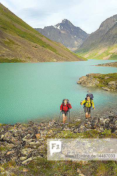 Male & female hikers on South Fork Eagle River Trail next to Eagle Lake in Chugach State Park Alaska Summer