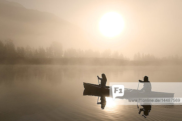 Paar Kanufahren @ Sonnenaufgang auf dem See Portage Valley SC AK Sommer im Nebel