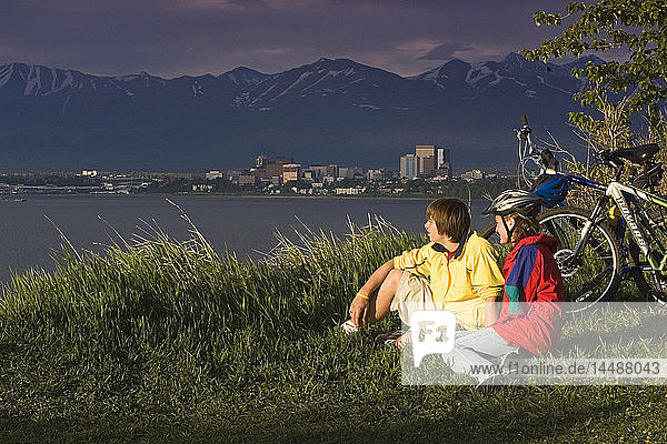 Junge und Mädchen telefonieren am Pt. Woronzof  während sie mit dem Fahrrad unterwegs sind Anchorage AK w/w/o bikes
