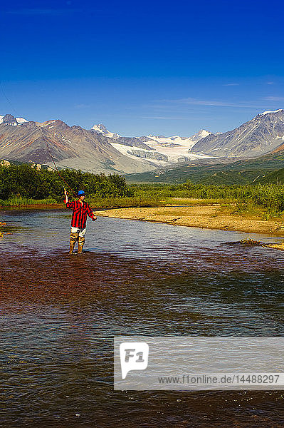 Mann beim Fliegenfischen im Gunn Creek am Richardson Highway mit dem Gulkana-Gletscher und der Alaska Range im Hintergrund  Innenalaska  Sommer