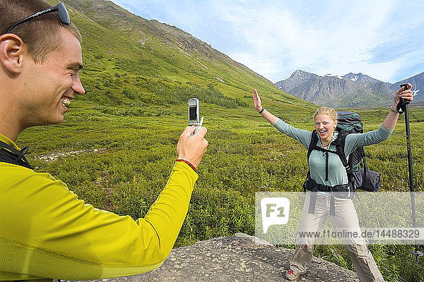 Wanderer fotografiert mit seinem Handy einen Freund auf dem South Fork Eagle River Trail im Chugach State Park Alaska Sommer