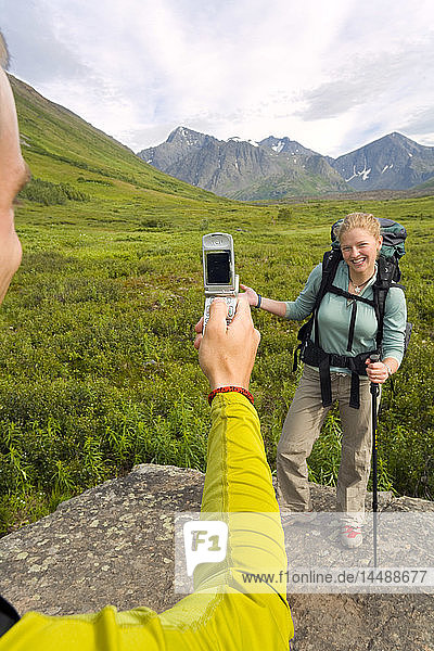 Wanderer fotografiert mit dem Handy einen Freund auf dem South Fork Eagle River Trail im Chugach State Park Alaska Sommer