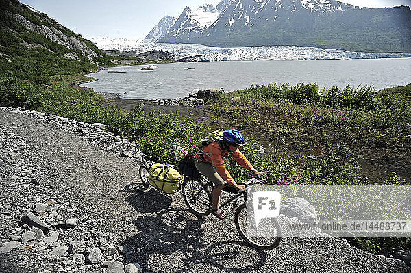 Woman bicycling on the trail to Spencer Glacier  Chugach National Forest  Kenai Peninsula  Southcentral Alaska  Summer