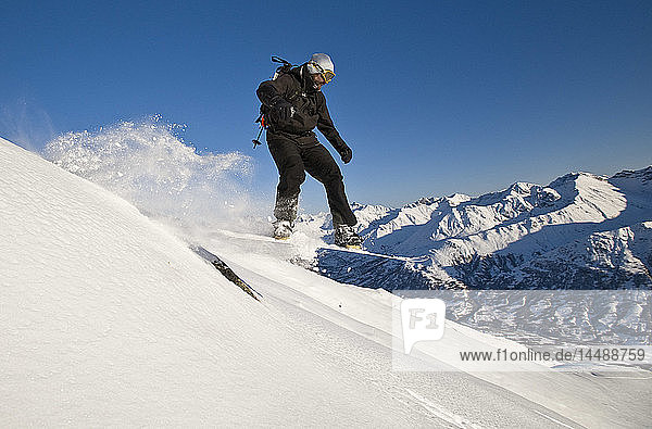 Ein Backcountry-Snowboarder schnappt beim Fahren am Hatcher Pass  Southcentral  Alaska  etwas Luft