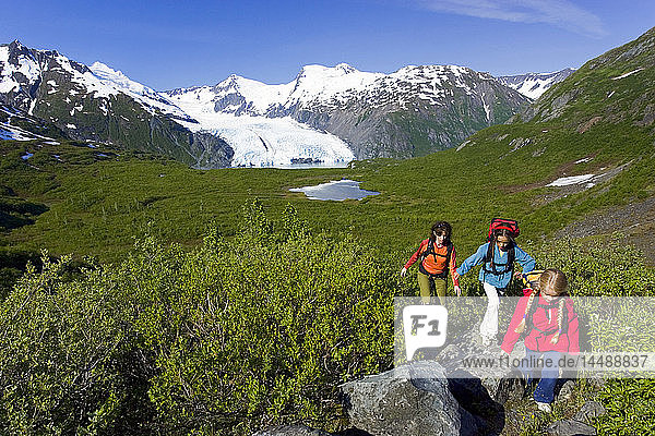 personFamily hiking together on Portage Pass Trail w/Portage Glacier Chugach Mtns & Nat Forest Alaska