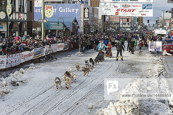 Kristy Berington runs down 4th avenue during the cermonial start day of Iditarod 2015.