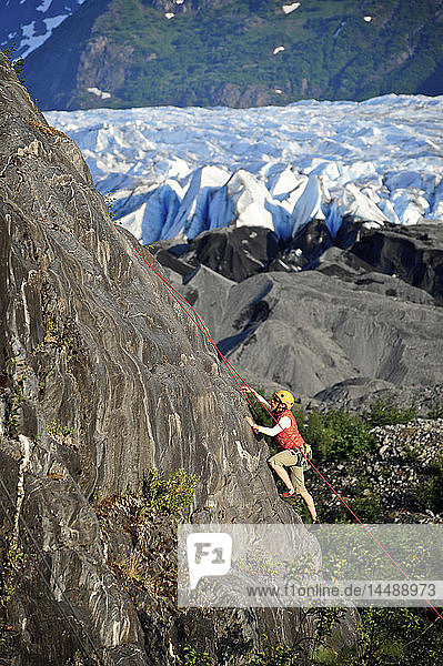 Frau beim Klettern mit Spencer Glacier im Hintergrund  Chugach National Forest  Kenai Peninsula  Southcentral Alaska  Sommer