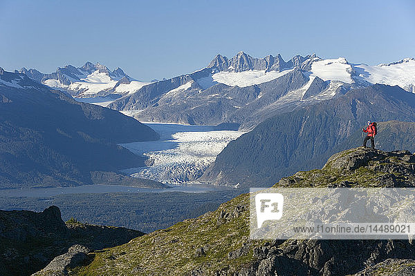 Man hiking in Alaska´s Tongass National Forest with view of Mendenhall Glacier near Juneau Alaska southeast Autumn