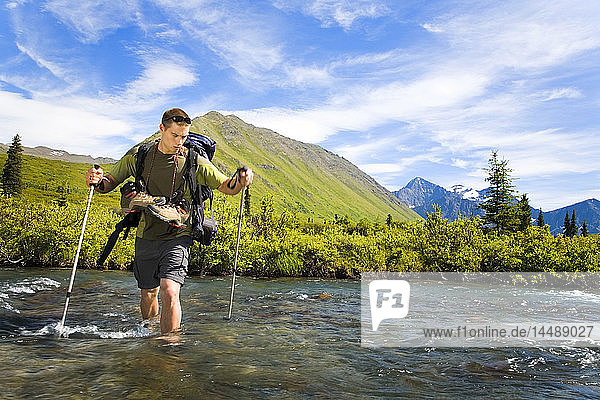 Männlicher Wanderer im Chugach State Park bei der Überquerung des South Fork of Eagle River unter Anwendung der richtigen Umgehungstechniken Alaska