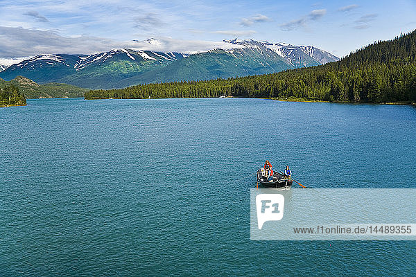 Anglers flyfishing from dory or drift boat at Kenai Lake on Kenai Peninsula  Southcentral  Alaska