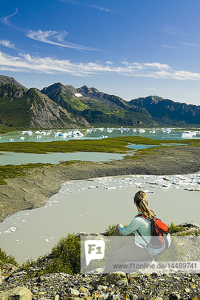 Female hiker overlooks Bear Glacier Lake in Kenai Fjords National Park  Kenai Peninsula  Southcentral Alaska  Summer