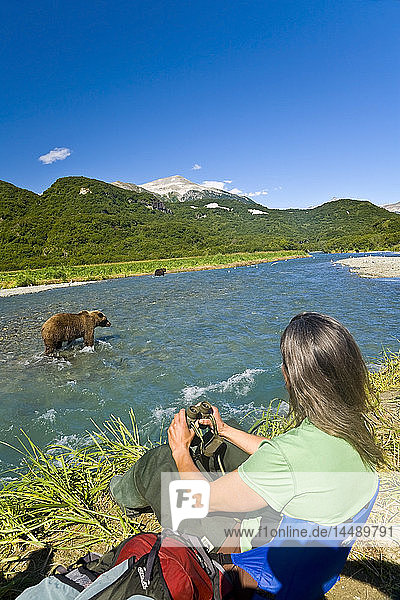 Fotografin fotografiert einen Grizzly in Geographic Harbor im Katmai National Park  Alaska