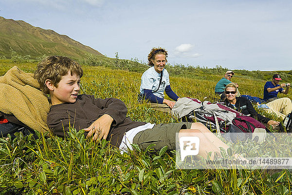 Group of hikers & guide rest on the tundra near Hightway Pass in Denali National Park  Interior Alaska