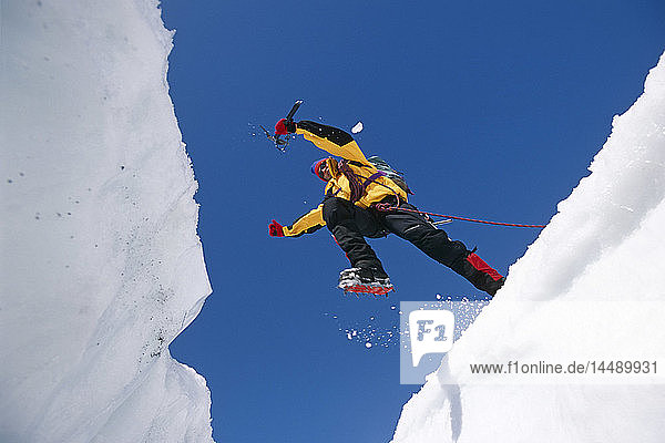 Eiskletterer springt über eine Gletscherspalte auf dem Matanuska-Gletscher SC AK