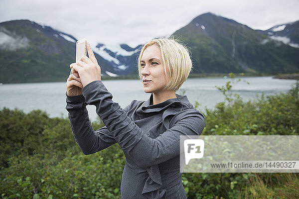 Frau  die in Portage Valley  Southcentral Alaska  mit ihrem Smartphone eine SMS schreibt