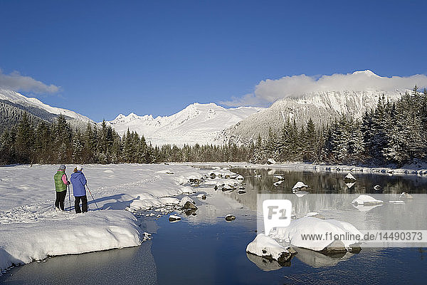 Mother & daughter cross-country skiing along Mendenhall River Alaska Winter Tongass Nat Forest