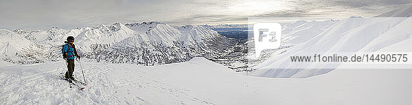 Ein Skitourengeher genießt die Aussicht vom Gipfel des Hatcher Pass  Alaska