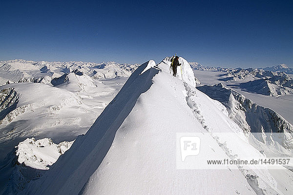 Männlicher Heli-Skifahrer steht auf einem schneebedeckten Bergrücken mit Blick auf die Chugach Mtn Range SC Alaska Winter