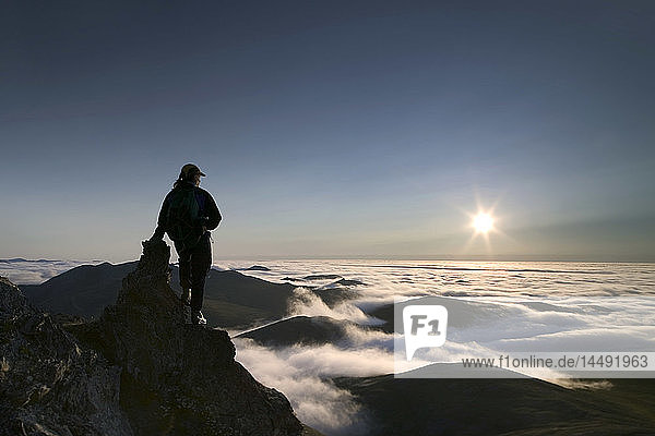 Hiker on Rock Views Cloud Layer Caribou Pass AK ANWR AR Brooks Range Silhouette