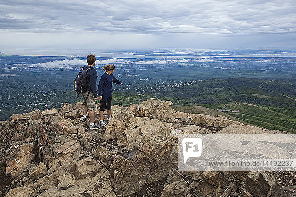 Couple stand near summit of Flat Top overlooking Anchorage  Alaska