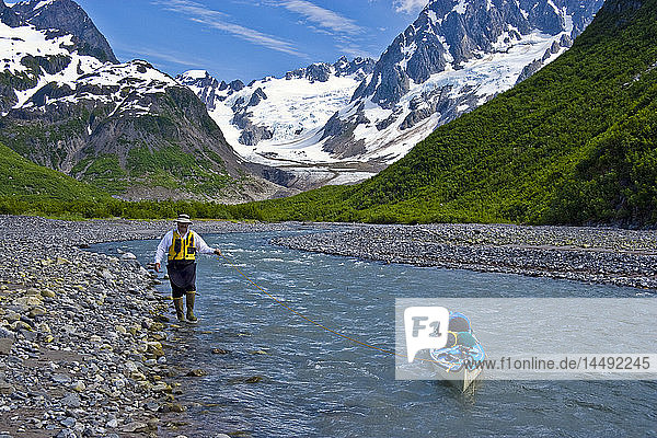 Männlicher Kajakfahrer  der mit seinem Kajak einen Fluss im nordwestlichen Fjord des Kenai Fjord National Park hinunterfährt  Kenai-Halbinsel  Süd-Zentral-Alaska  Sommer