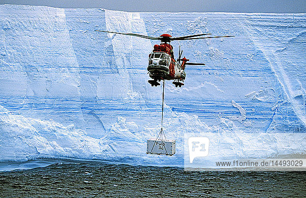 Helicopter carrying carton near glacier