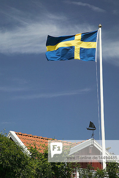 The Swedish flag outside a red cottage  Sweden.