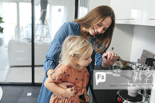 Mother with daughter making coffee